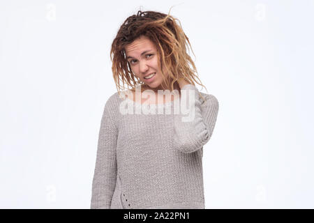 Giovane donna asiatica con dreadlocks accigliata la sua faccia avendo dubbi e sospetti sensazione. Essendo scettico circa qualcosa. Studio shot Foto Stock