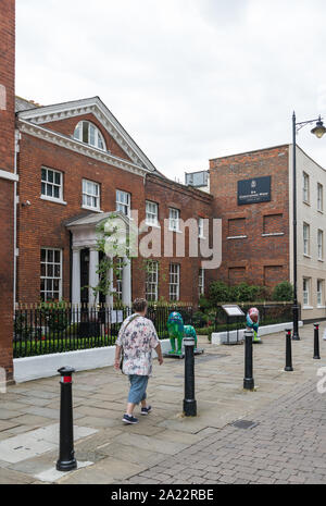 Casualmente vestito donna cammina passato The Sir Christopher Wren Hotel e Spa in Thames Street, Windsor, Berkshire, Inghilterra, Regno Unito Foto Stock