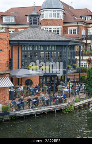 Persone e stare in compagnia gustando cibi e bevande rinfrescanti presso la Cote Brasserie ristorante francese sulla banca del fiume Tamigi a Eton, Berkshire, Regno Unito Foto Stock