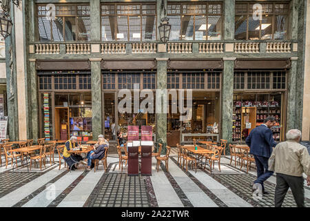 La gente seduta ai tavoli a mangiare cibo nella piscina ,art deco,soffitto di vetro arcade ,Galleria San Federico a Torino , Italia