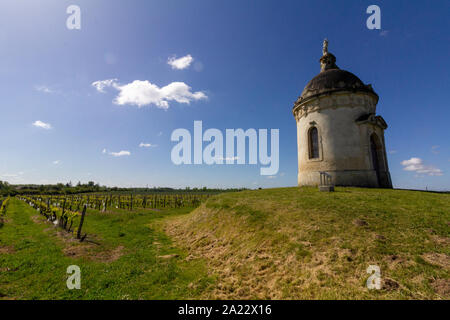 Trovati nel mezzo di un vigneto di Bordeaux, una torre rotonda cappella sorge su una piccola collina Foto Stock