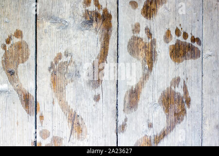 Molte impronte umido sul dell uomo un vecchio tavole di legno, per esterno Foto Stock