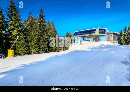 Bansko, Bulgaria - 20 dicembre 2018: Ski resort con vista sulle piste da sci, persone sciare giù da Kolarski a 6 posti ski seggiovia Foto Stock