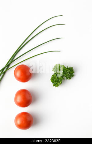 Il pomodoro fresco, erba cipollina e prezzemolo su sfondo bianco Foto Stock