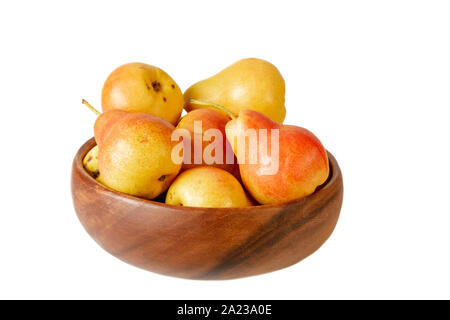 Pera in ciotola di legno su bianco. Pera organica frutta isolato su sfondo bianco. Foto Stock