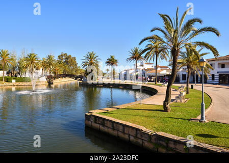 Mallorca, Spagna - 11 Maggio 2019: Palm alberi che crescono lungo un canale nella città di Alcudia a Mallorca Foto Stock