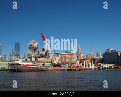 New Yok Harbour e pontili sul litorale di Manhattan con la costruzione di grandi navi e gru Foto Stock