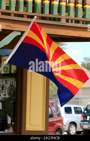 La Arizona State flag si diffonde nell'aria fresca al di fuori di un negozio in oggetto contrassegnato per la rimozione definitiva, AZ Foto Stock