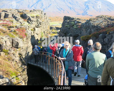 I turisti di seguire attraverso il sentiero attraverso la gola Almannagja a Thingvellir National Park, dove il North American & Eurasian placche tettoniche split. Foto Stock