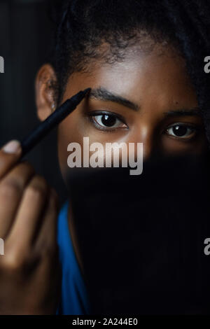 Giovane donna nera applicando compongono in specchio, Cali, Colombia Foto Stock