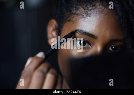 Giovane donna nera applicando compongono in specchio, Cali, Colombia Foto Stock