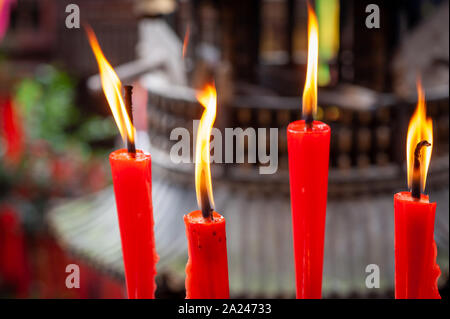 Red candele accese in un tempio taoista in QingChengShan, nella provincia di Sichuan, in Cina Foto Stock