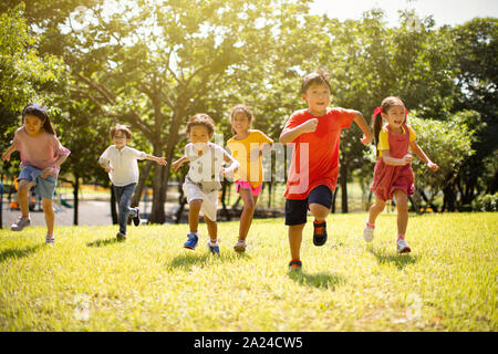 Multi-gruppo etnico dei loro figli a scuola a ridere e in esecuzione Foto Stock