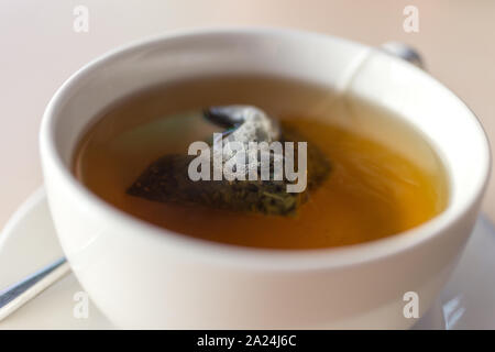 Tazza bianca tazza di erbe tè verde con bustine di the inside close up Foto Stock