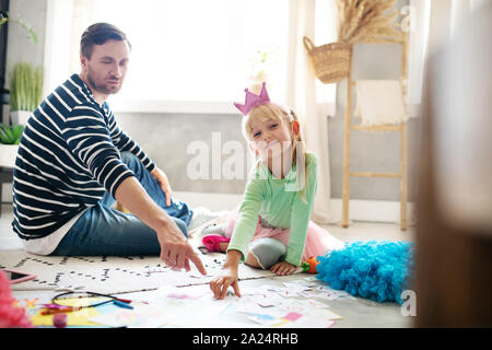 Ragazza carina sentirsi coinvolti nello studio con papà Foto Stock