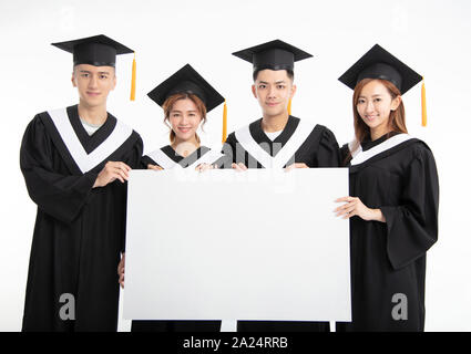 Gruppi di giovani studenti laureati presentando banner vuoto Foto Stock