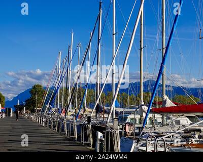 Velieri ormeggiati sul lago di Ginevra presso il porto di Ouchy con sullo sfondo le Alpi, Losanna, Svizzera. Foto Stock