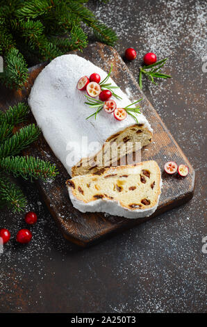 Natale Stollen. Tradizionale tedesco, festiva europea Dessert. Concetto di vacanza decorate con rami di abete e mirtilli rossi. Foto Stock