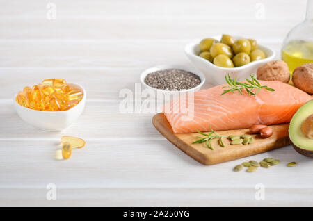 Selezione di un sano grassi insaturi omega 3 - pesce, avocado, olive, noci e semi. Foto Stock