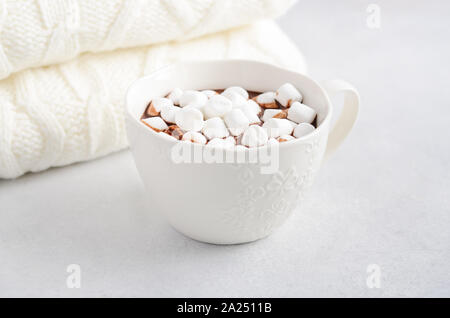 Tazza di cioccolata calda con marshmallows su un cemento grigio Sfondo. Foto Stock