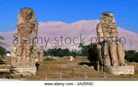 I Colossi di Memnon; sono due enormi statue di pietra del faraone Amenhotep III, che regnò in Egitto durante la dinastia XVIII. Poiché 1350 BC, hanno stava nella necropoli tebana, situato ad ovest del fiume Nilo dalla moderna città di Luxor. il tempio mortuario di Amenhotep III, noto anche come sistema Kom el-Hettân, costruito dall'architetto Amenhotep figlio di Habu, per il faraone Amenhotep III (o Amenhetep III) durante la XVIII Dinastia del Nuovo Regno. Foto Stock