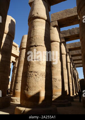 Le colonne al Tempio di Karnak, complesso di Luxor in Egitto. La costruzione del complesso ha iniziato durante il regno di Senusret I nel Regno di Mezzo e continuato nel periodo tolemaico, sebbene la maggior parte degli edifici esistenti data dal Nuovo Regno. La zona intorno a Karnak è stata il principale luogo di culto della XVIII dinastia Theban Triad con il dio Amon come la sua testa. Essa è parte della città monumentale di Tebe. Foto Stock