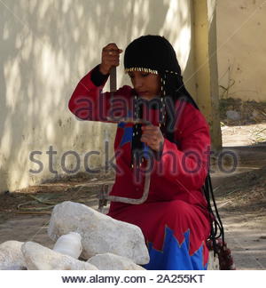Rievocazione di un antico egiziano scalpellino femmina carving da un blocco di alabastro Foto Stock
