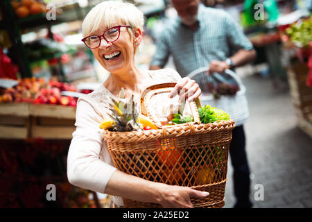 Solo i migliori frutti e verdure. Bella donna matura l'acquisto di alimenti freschi sul mercato Foto Stock