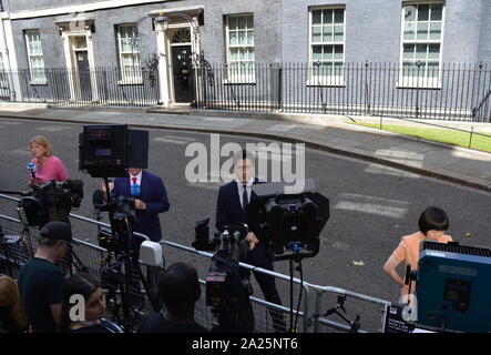 Premere riuniti a Downing Street, Londra, come rimozioni van toglie possedimenti del primo ministro uscente e Theresa Maggio. le residenze ufficiali e gli uffici del primo ministro del Regno Unito e il cancelliere dello scacchiere. situato fuori di Whitehall, a pochi minuti a piedi dalla casa del parlamento, Downing Street è stato costruito nel 1680s da sir George downing. Foto Stock