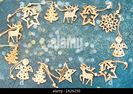 Legno Ornamenti natale disposti in un cerchio su sfondo blu con un bellissimo bokeh di fondo, vista dall'alto Foto Stock