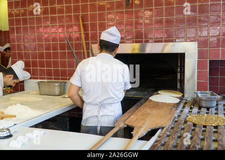 Chef al lavoro, l'uomo la preparazione lahmacun. Cibo turco tradizionale aka Turkish Pizza. Foto Stock