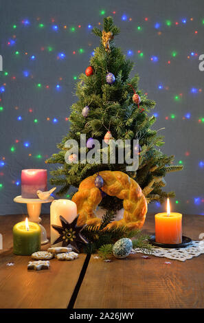Albero di natale con un rituale di pane tondo le candele, una stella, biscotti di panpepato e ornato di uova sul tavolo Foto Stock