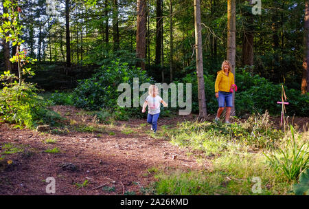 Due giovani anno vecchia ragazza giocando nei boschi con sua nonna divertendosi Foto Stock