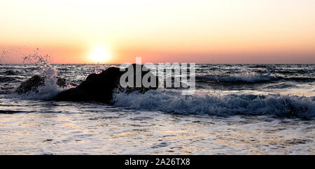 Bel tramonto (sunrise) sul mare, onde bellissime. Messa a fuoco selettiva. Foto Stock