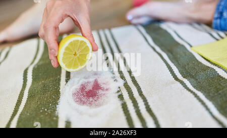 Limone e sale come un rimedio casalingo per la rimozione delle macchie del vino rosso sul tappeto Foto Stock