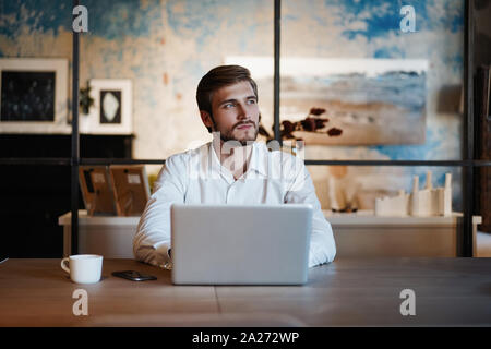 Imprenditore bello lavorare con il computer portatile in ufficio Foto Stock