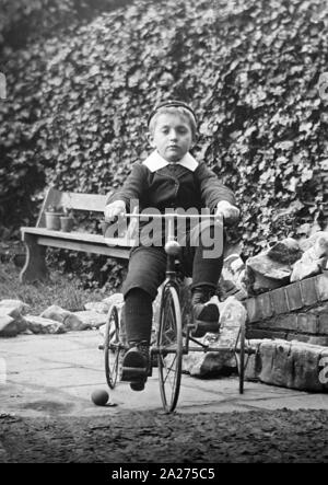 Ragazzo giocando su triciclo, agli inizi del novecento Foto Stock