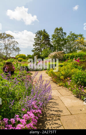 I letti del Giardino delle Rose sono riempiti con una ricca varietà di piante perenni e arbusti a Burrow Agriturismo Giardini, vicino, Axminster Devon, Inghilterra, Regno Unito Foto Stock