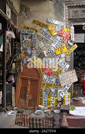 Arnese da cucina venditore shop con veicolo targhe di immatricolazione, Stone Town, Zanzibar, isola di Unguja, Tanzania. Foto Stock