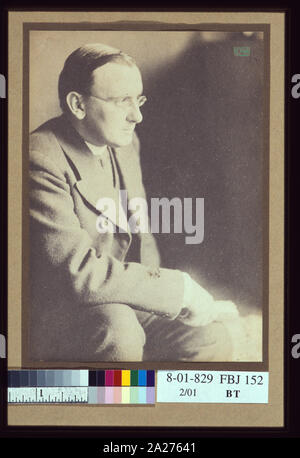 Ritratto di uomo con gli occhiali, seduto con il gomito poggiato sul ginocchio destro / EW Foto Stock