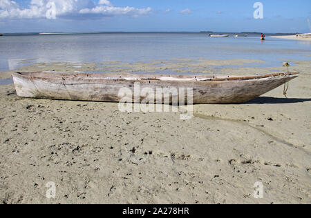 Vecchio vuoto pesca in legno Canoe sulla spiaggia con montante giù, Zanzibar, isola di Unguja, Tanzania. Foto Stock