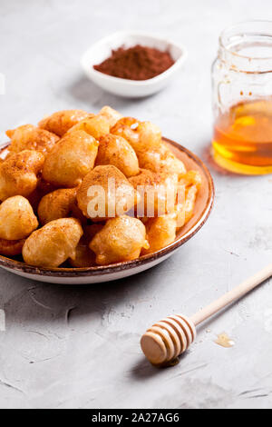 Piastra della casalinga ciambelle greche loukoumades con miele e cannella Foto Stock