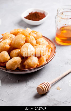 Piastra della casalinga ciambelle greche loukoumades con miele e cannella Foto Stock