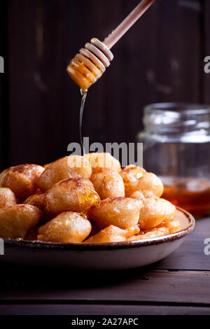 Piastra della casalinga ciambelle greche loukoumades con miele e cannella Foto Stock