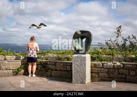 Donna e seagull con la scultura di Barbara Hepworth e vista mare dietro Foto Stock