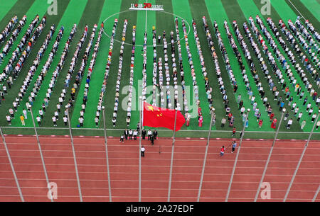 (191001) -- GUIYANG, 1 ottobre, 2019 (Xinhua) -- Un alzabandiera cerimonia per celebrare il settantesimo anniversario della fondazione della Repubblica popolare cinese (RPC) viene trattenuto nel Guizhou Minzu University di Guiyang, capitale del sud-ovest della Cina di Guizhou, 1 ottobre, 2019. (Xinhua/Yang Wenbin) Foto Stock