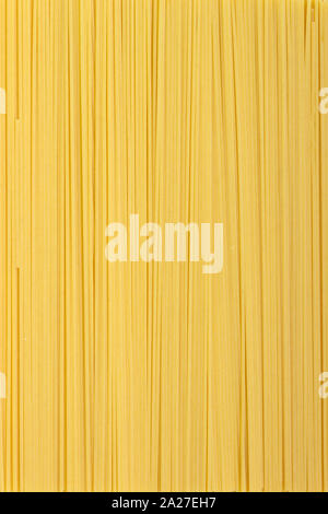 Pasta sottile disposti in righe. Giallo pasta italiana. Spaghetti lunghi. Materie spaghetti sfondo. Alimentare il concetto di sfondo. Foto Stock