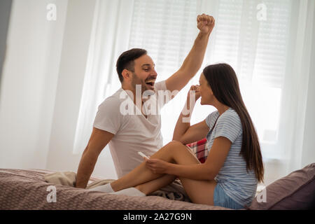 Coppia giovane è felice perché di positivo al test di gravidanza. Foto Stock