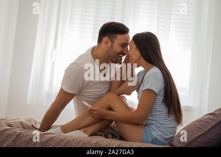 Coppia giovane è felice perché di positivo al test di gravidanza. Foto Stock