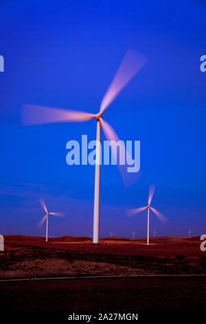 Il mulino a vento di turbine a vento la filatura veloce nel vento al tramonto o l'alba Foto Stock